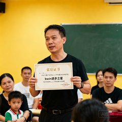 广州学员家长王先生在家长会上分享孩子引体向上从零到满分的训练历程，手中拿着bwin颁发的进步之星证书
